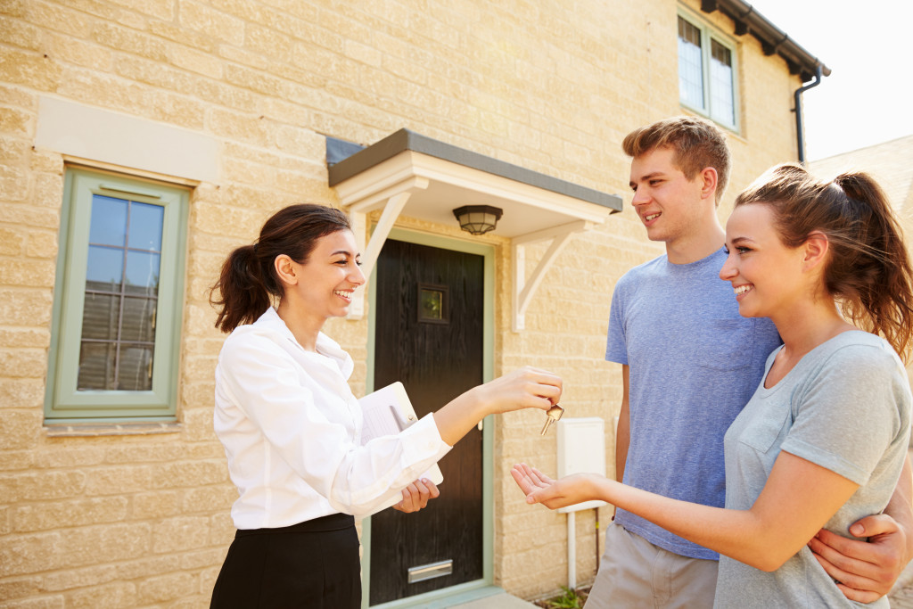 real estate agent handing over house keys to a couple