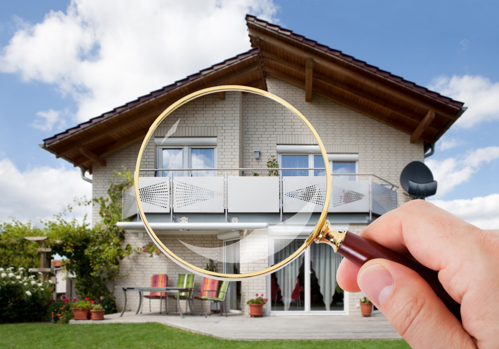 a person with magnifying glass looking over at a house